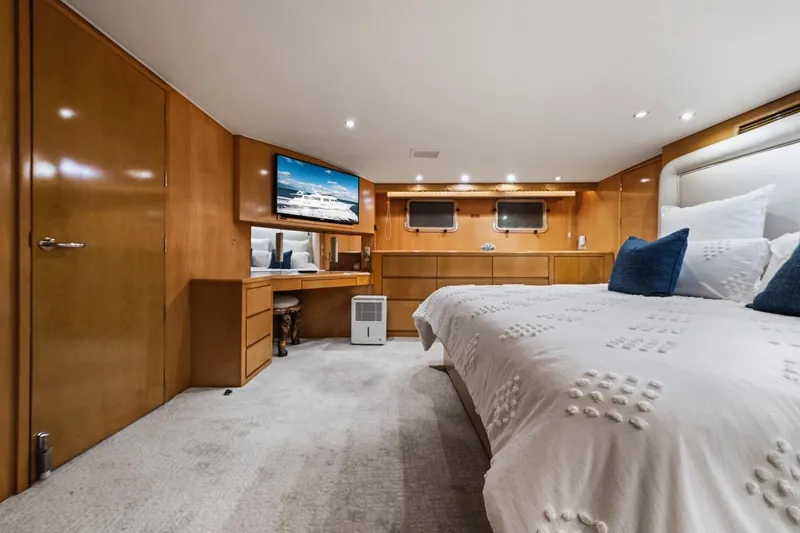 Slide: The Image of Luxurious bedroom interior of 2000 Hatteras 74 Cockpit Motor Yacht with wood paneling. - 45
