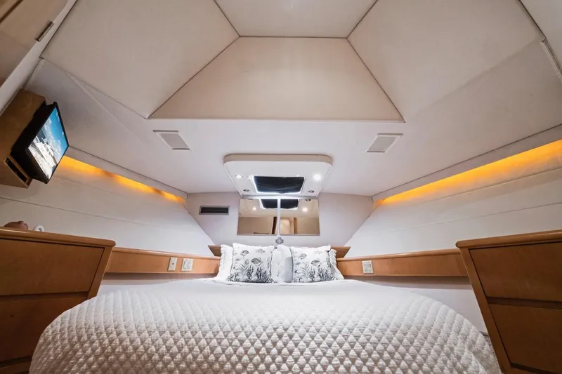 Slide: The Image of Luxurious bedroom interior of 2000 Hatteras 74 Cockpit Motor Yacht with elegant bedding and ambient lighting. - 47