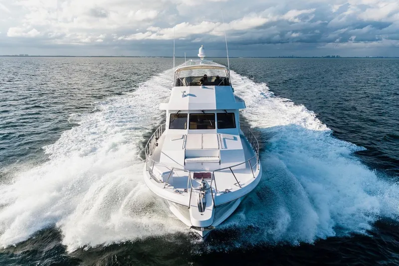 Slide: The Image of Hatteras 74 Cockpit Motor Yacht 2000 cruising on open water under cloudy skies. - 6
