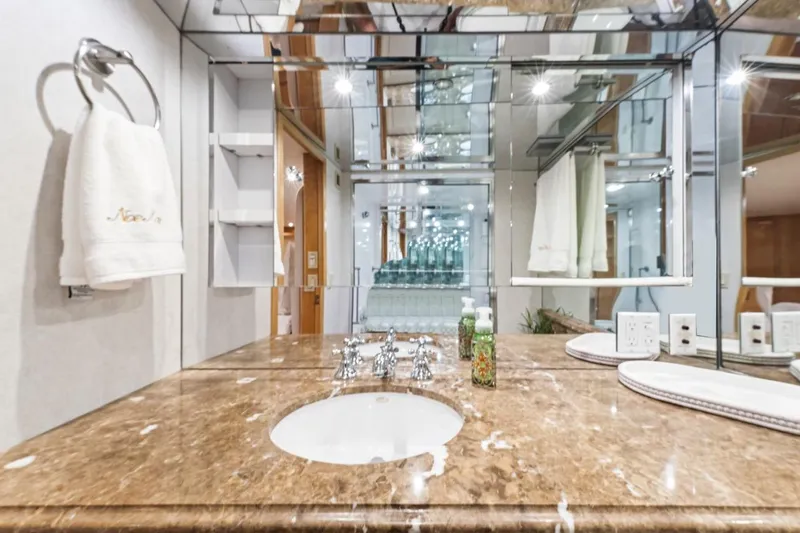 Slide: The Image of Luxurious bathroom in 2000 Hatteras 74 Cockpit Motor Yacht with marble countertop and mirrored walls. - 60