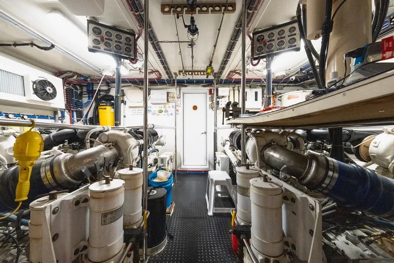 Slide: The Image of Engine room of 2000 Hatteras 74 Cockpit Motor Yacht, showcasing machinery and equipment. - 62