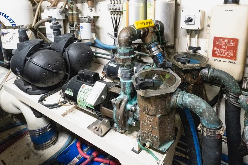 Slide: The Image of Engine room of 2000 Hatteras 74 Cockpit Motor Yacht with pumps and piping. - 63
