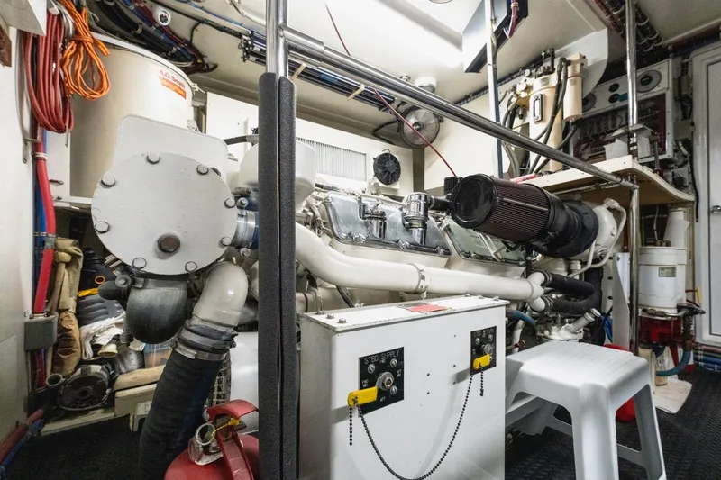 Slide: The Image of Engine room of 2000 Hatteras 74 Cockpit Motor Yacht, showcasing mechanical components and equipment. - 65