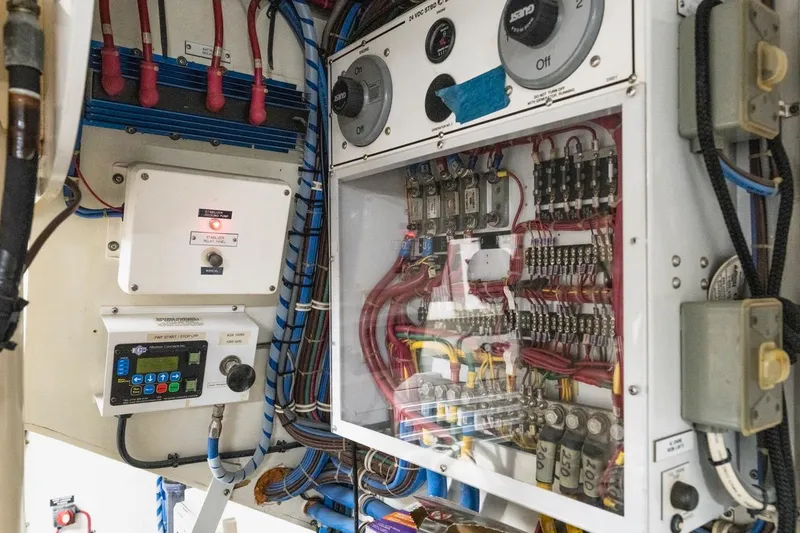 Slide: The Image of Electrical panel of a 2000 Hatteras 74 Cockpit Motor Yacht, showcasing wiring and controls. - 69