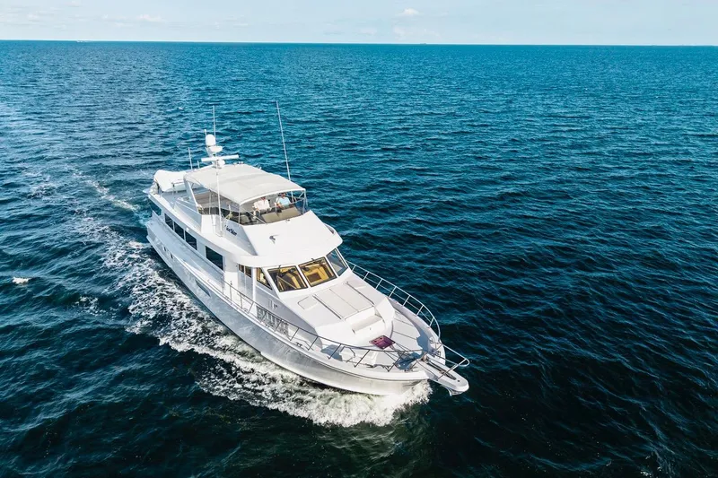 Slide: The Image of 2000 Hatteras 74 Cockpit Motor Yacht cruising on open ocean waters. - 7