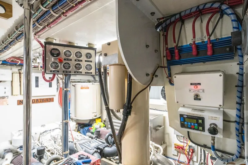 Slide: The Image of Engine room of 2000 Hatteras 74 Cockpit Motor Yacht with control panels and wiring. - 71