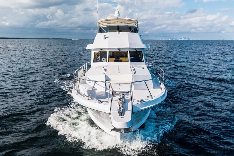 Slide: The Image of 2000 Hatteras 74 Cockpit Motor Yacht cruising on open water under a cloudy sky. - 8