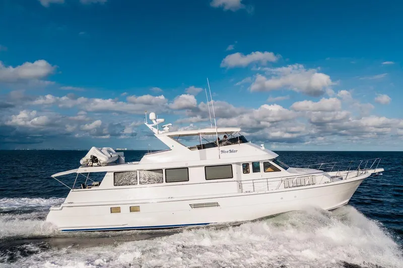 Slide: The Image of 2000 Hatteras 74 Cockpit Motor Yacht cruising on open sea under blue sky. - 9