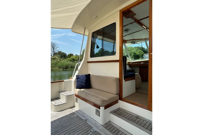 Slide: The Image of 2004 Bruckmann Bluestar 38 boat interior with seating, open door, and scenic view. - 11