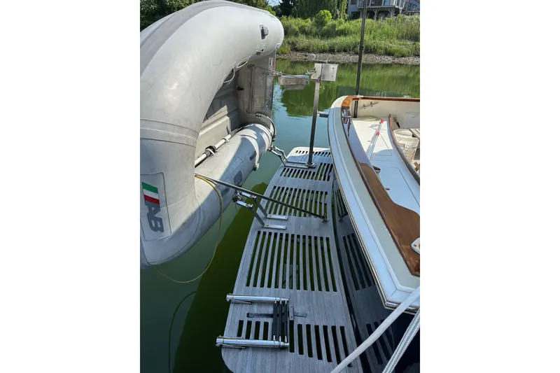 Slide: The Image of Bruckmann Bluestar 38 (2004) with inflatable dinghy on water, docked near greenery. - 12