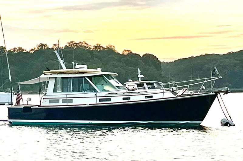 Slide: The Image of 2004 Bruckmann Bluestar 38 yacht anchored at sunset with scenic background. - 16