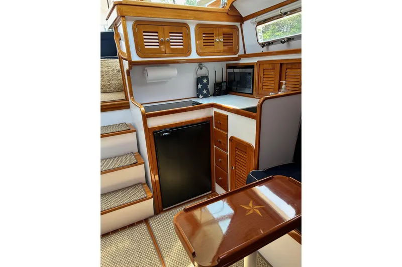 Slide: The Image of Interior of 2004 Bruckmann Bluestar 38 yacht with wooden cabinetry and compact kitchen area. - 35