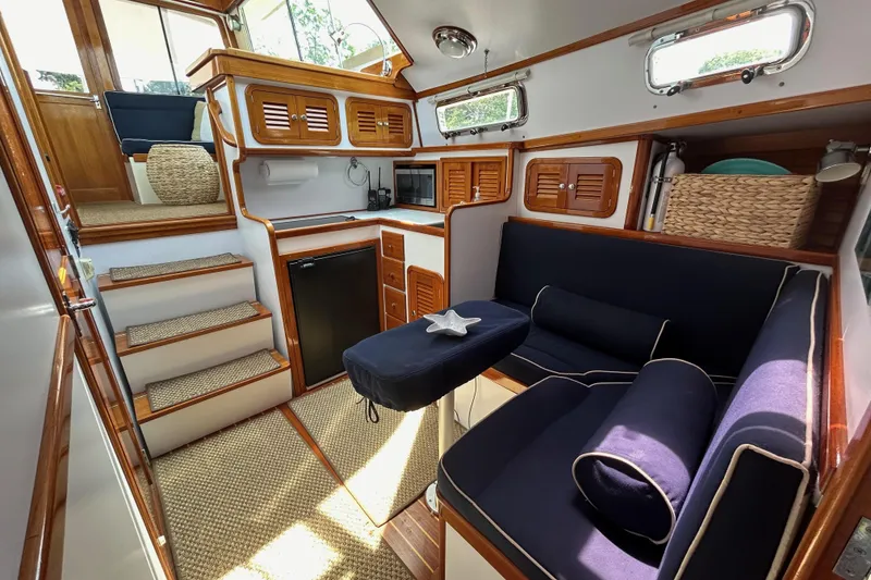 Slide: The Image of Interior of 2004 Bruckmann Bluestar 38 yacht with cozy seating and wooden cabinetry. - 4