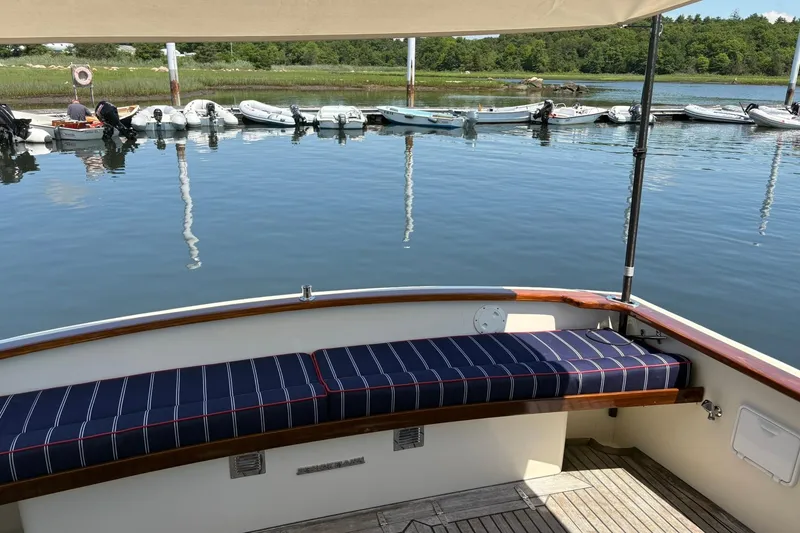 Slide: The Image of Bruckmann Bluestar 38 boat, 2004 model, with striped seating, docked by calm water. - 48