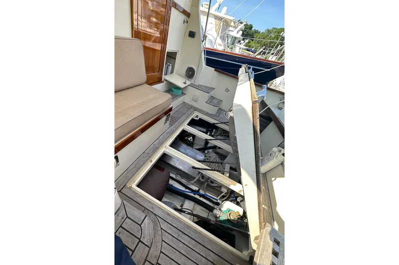 Slide: The Image of 2004 Bruckmann Bluestar 38 boat interior with open engine compartment, wooden deck, and seating area. - 54