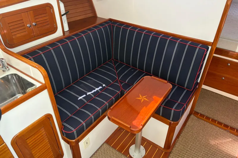 Slide: The Image of Interior of 2004 Bruckmann Bluestar 38 yacht with striped seating and wooden table. - 44