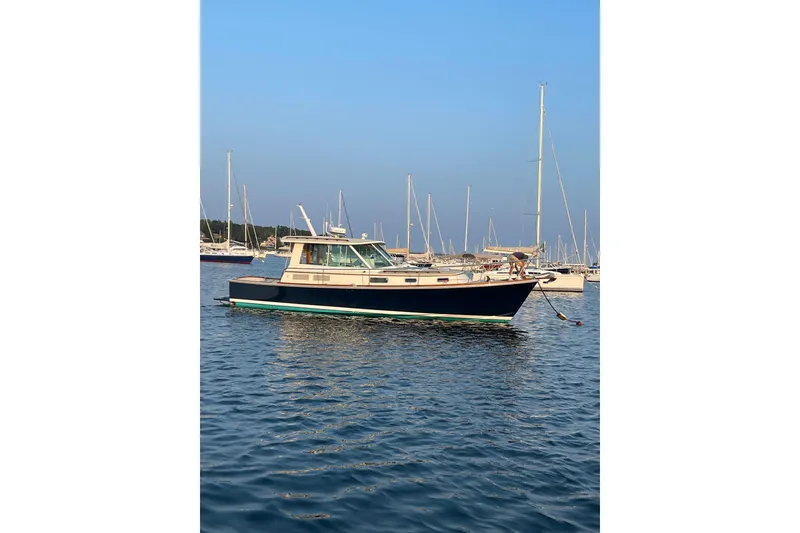 Slide: The Image of 2004 Bruckmann Bluestar 38 yacht anchored in a serene marina setting. - 8