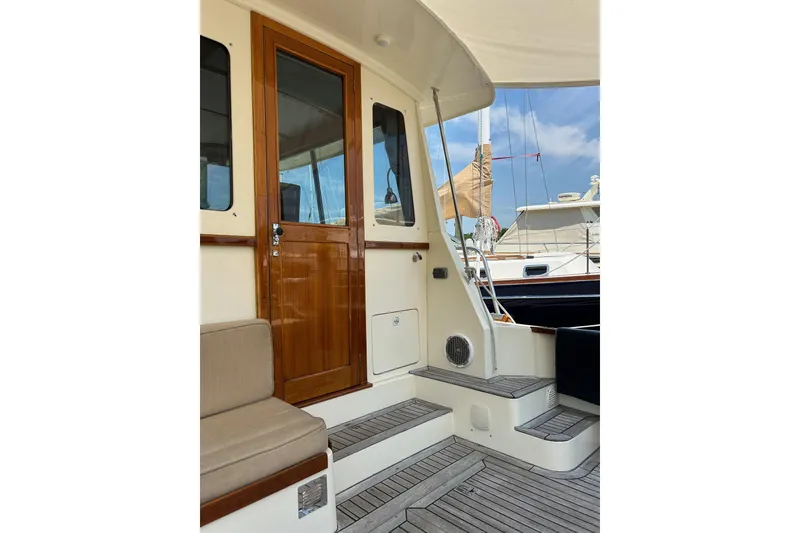 Slide: The Image of Bruckmann Bluestar 38 yacht, 2004 model, featuring teak deck and wooden door. - 9