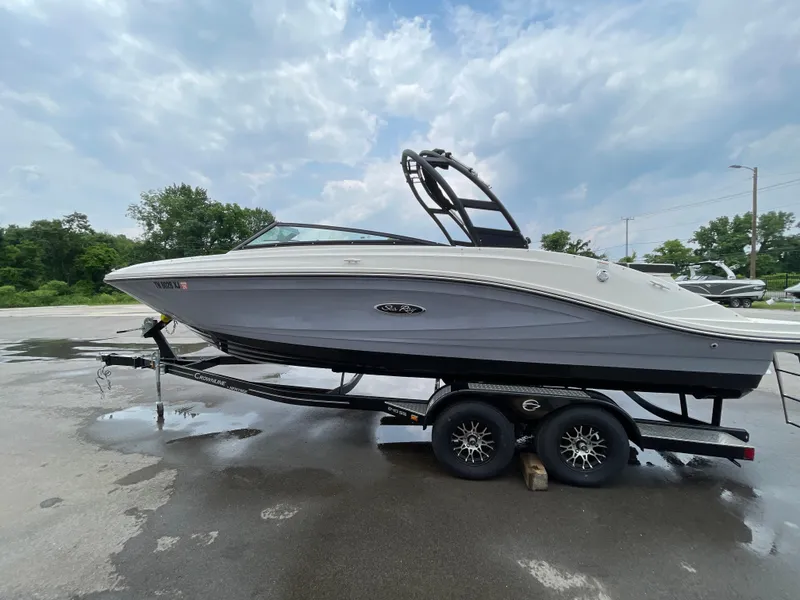 Slide: The Image of 2023 Sea Ray SPX 230 boat on trailer under cloudy sky. - 1