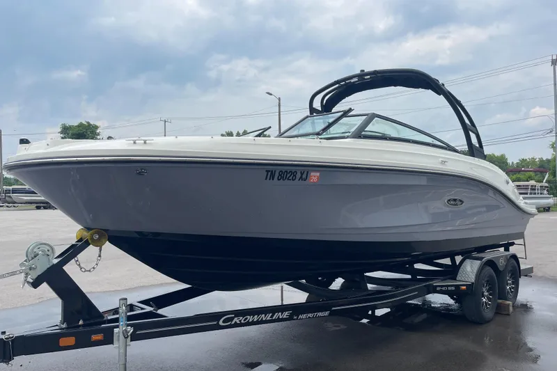 Slide: The Image of 2023 Sea Ray SPX 230 boat on trailer, parked outdoors under cloudy sky. - 2