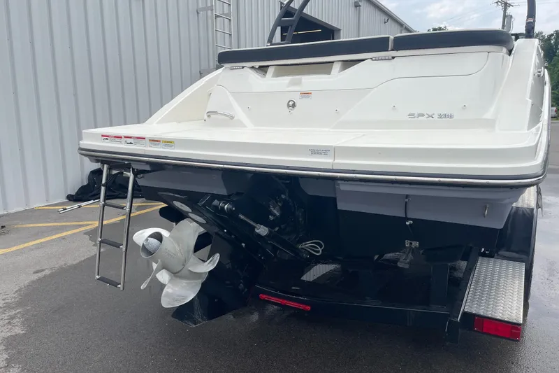 Slide: The Image of 2023 Sea Ray SPX 230 boat rear view with propeller and ladder. - 4