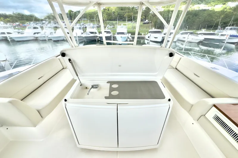Slide: The Image of 2020 Tiara Yachts F53 Flybridge interior with seating and kitchenette, docked at marina. - 24