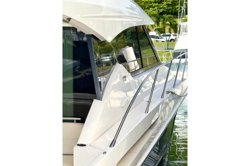 Slide: The Image of 2020 Tiara Yachts F53 Flybridge, sleek design, docked by lush greenery. - 3
