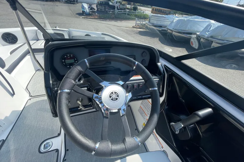 Slide: The Image of 2026 Yamaha Boats AR195 steering wheel and dashboard in a marina setting. - 6