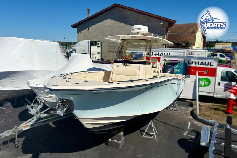 Slide: The Image of 2023 Grady-White Canyon 271 boat displayed outdoors near U-Haul trucks. - 2