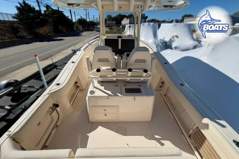 Slide: The Image of 2023 Grady-White Canyon 271 boat interior with seating and console, docked outdoors. - 6