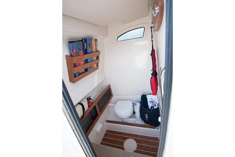 Slide: The Image of 2023 Grady-White Canyon 271 boat interior with compact bathroom and storage. - 9