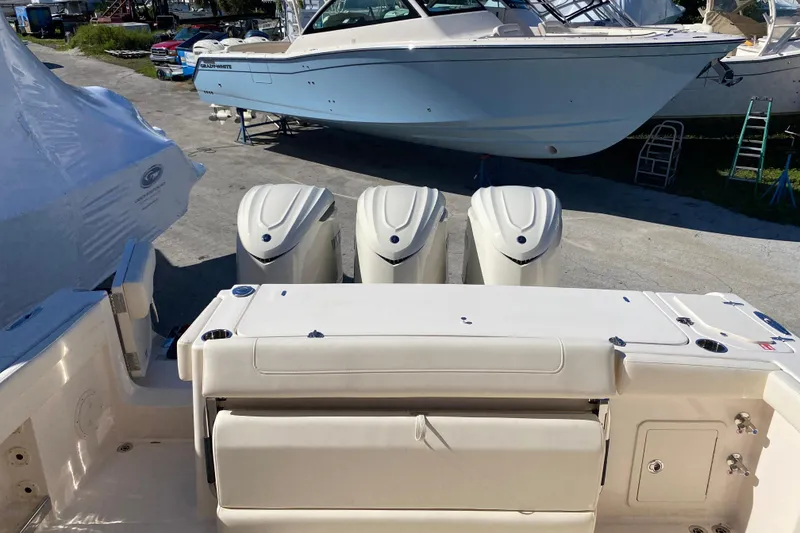 Slide: The Image of 2026 Grady-White Canyon 336 boat with triple outboard engines, docked outdoors. - 17