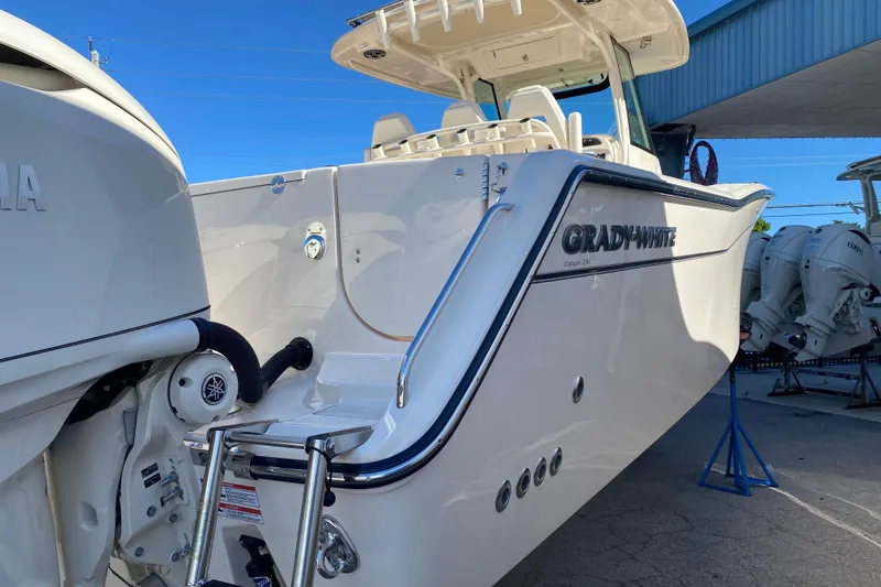 Slide: The Image of 2026 Grady-White Canyon 336 boat with Yamaha outboard engines, docked under a blue sky. - 2