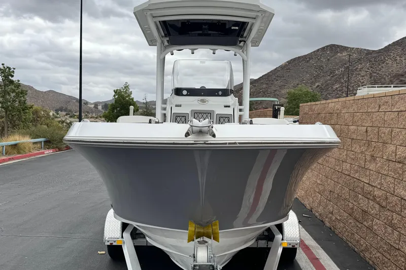 Slide: The Image of 2022 Wellcraft 222 Scarab Offshore boat on trailer, parked near mountains. - 2