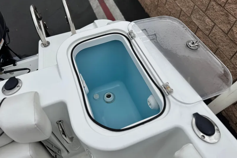 Slide: The Image of 2022 Wellcraft 222 Scarab Offshore boat with open storage compartment and clear lid. - 22