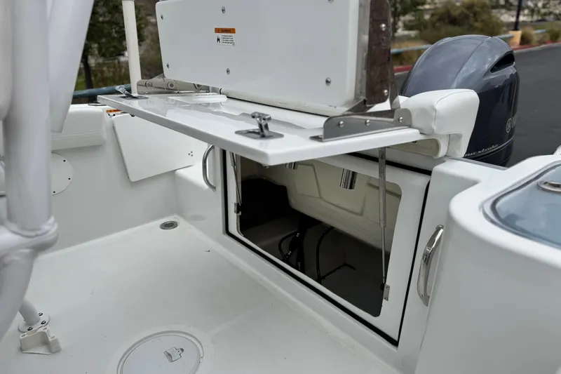 Slide: The Image of 2022 Wellcraft 222 Scarab Offshore boat with open storage compartment and Yamaha outboard motor. - 24