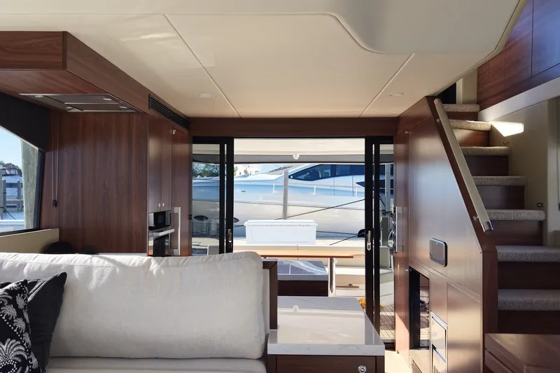 Slide: The Image of Innenraum einer luxuriösen Yacht mit Holzmöbeln und Treppe, Blick auf das Wasser durch große Fenster. - 10