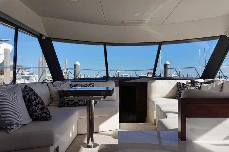 Slide: The Image of Innenraum einer luxuriösen Yacht mit weißen Sofas und großen Fenstern mit Blick auf den Hafen. - 12