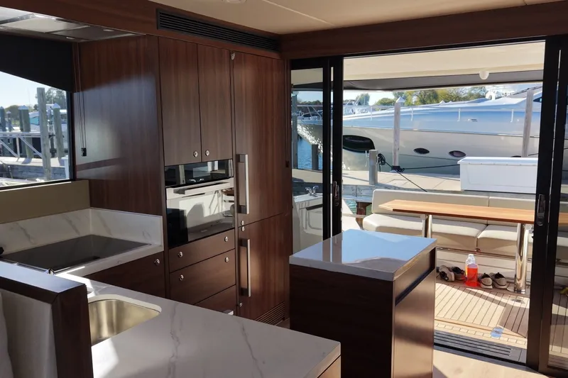 Slide: The Image of Die Küche einer modernen Yacht mit Holzschränken und Edelstahlgeräten, die zu einem offenen Deck führt. - 11