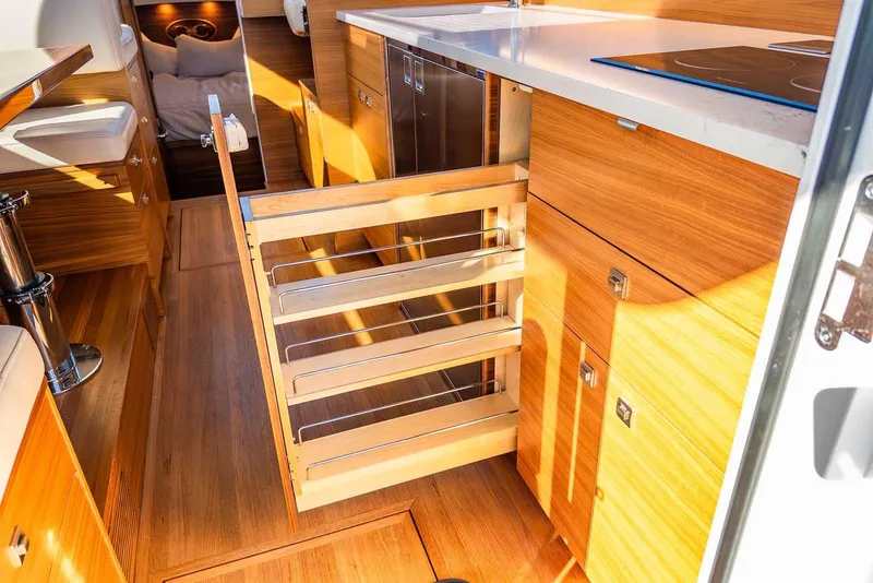 Slide: The Image of Interior of 2020 Coastal Craft 33 Express yacht with modern wooden cabinetry and pull-out storage. - 21