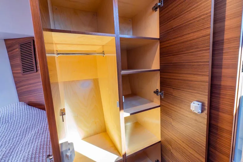 Slide: The Image of Interior storage of 2020 Coastal Craft 33 Express yacht with wooden shelves and closet space. - 25