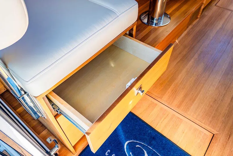 Slide: The Image of Open drawer in 2020 Coastal Craft 33 Express yacht interior, featuring wooden flooring and cushioned seating. - 27