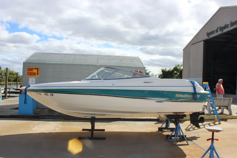 The Image of 2000 Wellcraft 186 SS/S boat on stands outside a storage facility. - 0