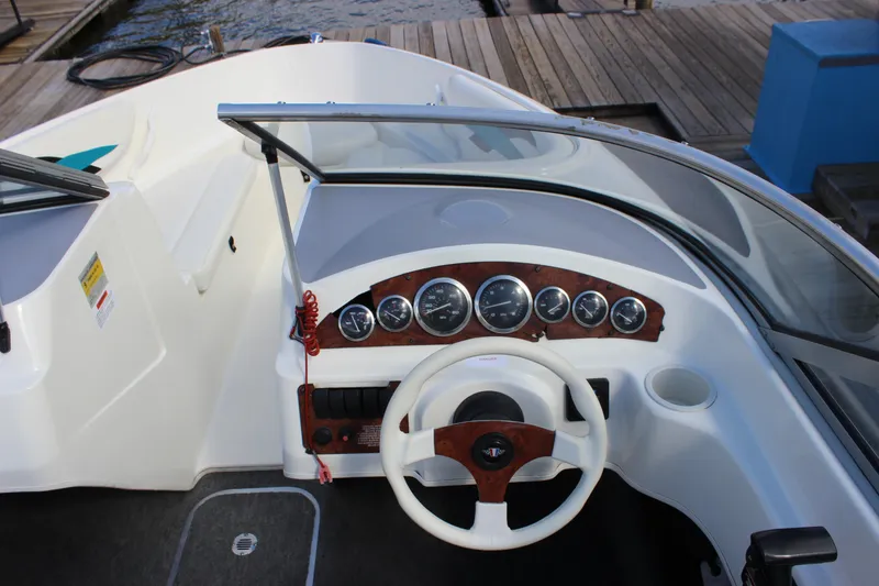 Slide: The Image of 2000 Wellcraft 186 SS/S boat dashboard with steering wheel and gauges, dockside view. - 20