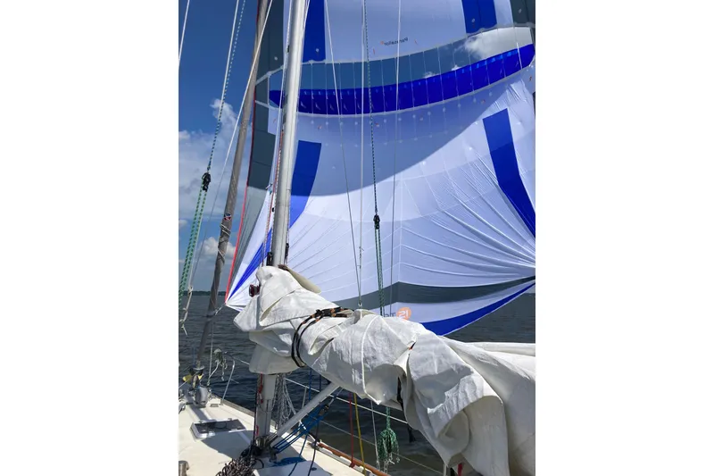 Slide: The Image of 1982 Tartan 33 sailboat with blue and white spinnaker on a sunny day. - 3