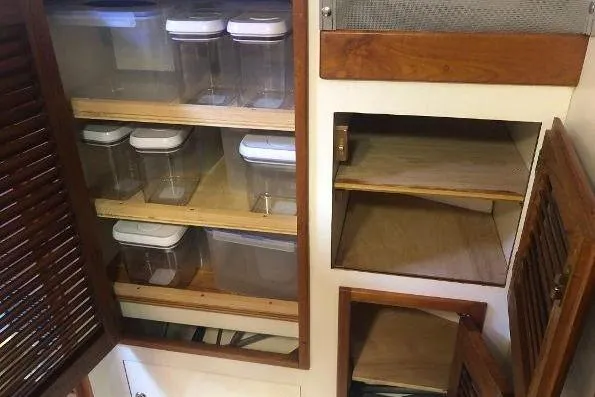 Slide: The Image of Cabin storage with clear containers in a 1982 Tartan 33 sailboat. - 30
