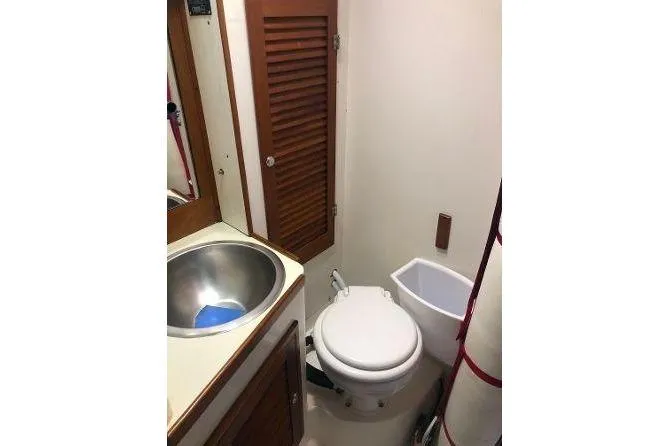 Slide: The Image of 1982 Tartan 33 yacht bathroom with sink, toilet, and wooden cabinetry. - 32