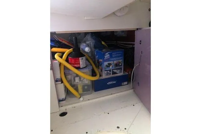Slide: The Image of Storage compartment in a 1982 Tartan 33 sailboat with various supplies and equipment. - 34