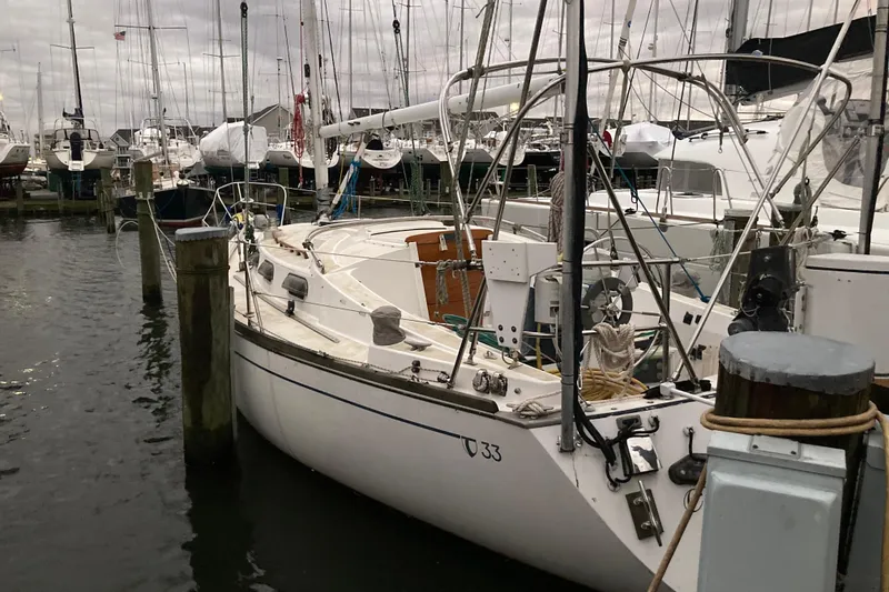 Slide: The Image of 1982 Tartan 33 sailboat docked at a marina, surrounded by other boats. - 4
