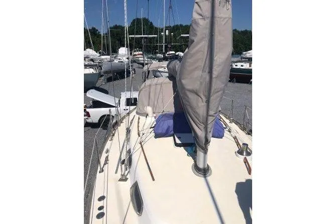 Slide: The Image of 1982 Tartan 33 sailboat on land, covered mast, surrounded by other boats. - 5
